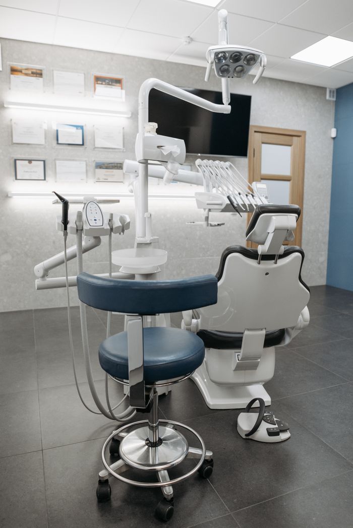 Clean and contemporary dentist office with modern equipment and empty chair, ready for patients.