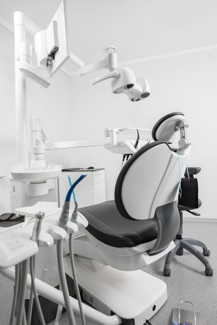 Bright and sterile dental clinic room featuring modern equipment and a dental chair.
